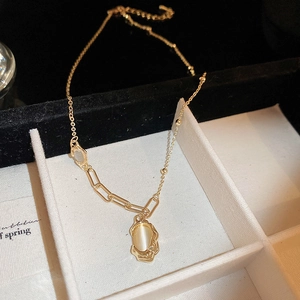 Detail of gold necklace with oval tiger eye pendant inside a luxury jewelry gift box