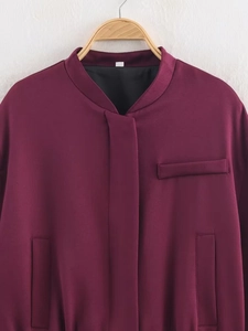Detail der weinroten Bomberjacke mit Twill-Struktur und Brusttaschendesign am Kragen