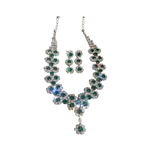 Elegant silver sunflower jewelry set with green and white crystals on a white background