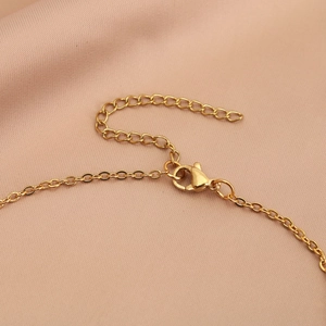 Gold heart necklace detail showing lobster clasp and 5cm extender chain on satin