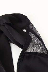 Dettaglio dell'elegante raso nero con pizzo raffinato sull'abito con schiena scoperta
