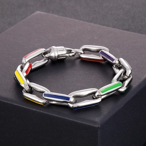 Detail shot of multicolor enamel hollow cuban link bracelet on a textured jewelry box