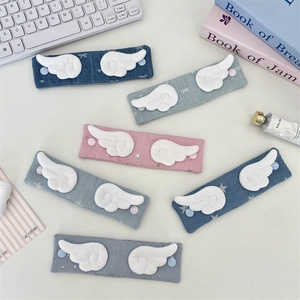 Detailed close-up of colorful fabric cable organizers with cute plush angel wings