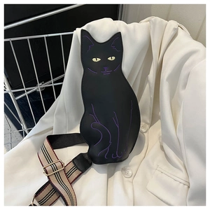 Detail of cute black cat crossbody bag featuring purple embroidery and striped strap