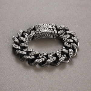 Detail of vintage punk stainless steel bracelet with trident pattern and textured metal links
