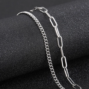 Macro detail of silver curb chain and paperclip link necklace in titanium steel