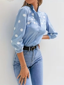 Camicetta celeste da donna con ricami floreali bianchi e maniche a sbuffo eleganti