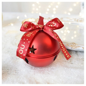 Macro view of matte red Christmas bell with star cutouts and printed silk ribbon