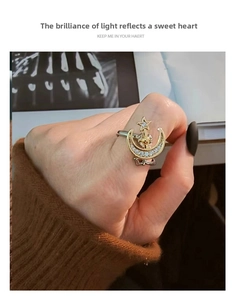 Close-up of star and moon spinner ring with sparkling crystals on a female model