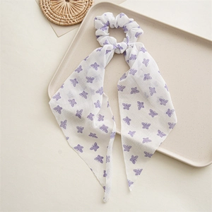 Detail of white chiffon hair scrunchie with purple butterfly print and long streamers