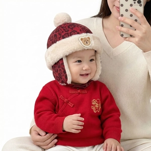 Détail du bonnet d'hiver pour bébé avec doublure léopard, fausse fourrure et écusson ours