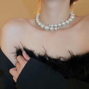 Close-up of oversized faux pearl choker with metallic beads on female model neck