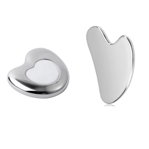 Detail view of heart-shaped stainless steel massage tools for skin cooling and facial care