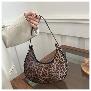 Detailed view of leopard print shoulder bag held by model in a vintage interior setting