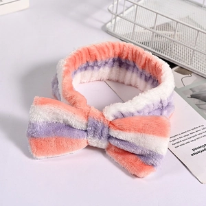 Detail of pink and purple striped coral fleece headband with large bow for face washing