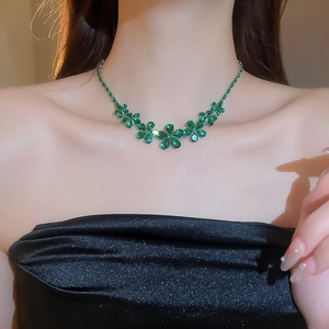 Close-up of green zircon flower necklace with pear-cut gems on model's neckline