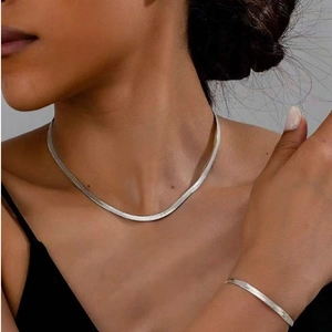 Silver flat herringbone snake chain necklace and bracelet jewelry set on model
