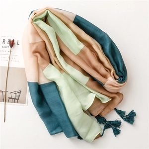 Detailed view of lightweight scarf with tassel fringe and colorful geometric pattern