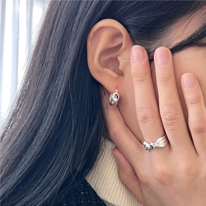 Minimalist 925 sterling silver knot earrings and bow ring set worn by a female model