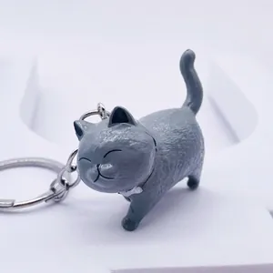 Cartoon grey cat keychain figurine with a smiling expression on a white background