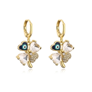 Detailed macro view of gold-plated clover earrings with evil eye and crystal hearts