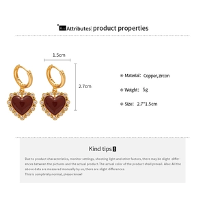 Macro detail of vintage Ankara red heart earrings with gold plating and zircon stones