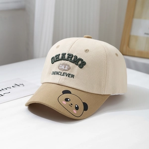 Détail des lettres brodées vertes et de l'imprimé panda sur la casquette de baseball crème