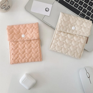 Detailed view of two quilted heart patterns on soft storage bags with resin snap closures