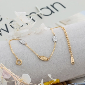 Macro detail of the S925 sterling silver chain with leaf-shaped engraved two-tone charms