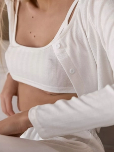 Detail of white knit lounge set featuring pointelle stitch and button-down cardigan