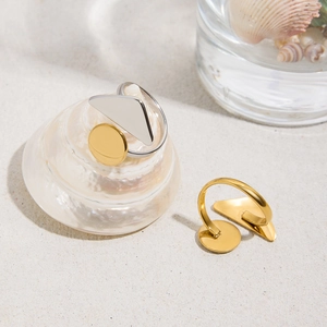 Chic gold and silver geometric titanium steel rings displayed on white beach sand