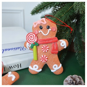 Detail of gingerbread man Christmas ornament with red scarf and candy cane detail