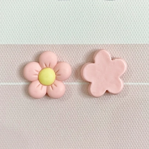 Close-up of pink resin five-petal flower charms for DIY crafts and phone case decor