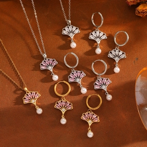 Détail à plat de parures de bijoux en feuilles de ginkgo avec zircons et perles