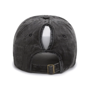 Detail of ponytail hole and adjustable antique metal buckle on washed denim baseball cap