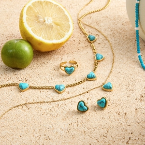 Vue à plat de l'ensemble bijoux turquoise cœur doré avec collier bague et boucles