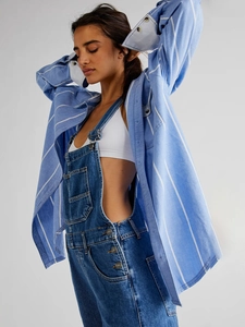 Classic dark blue denim dungarees with striped shirt in a stylish outdoor look