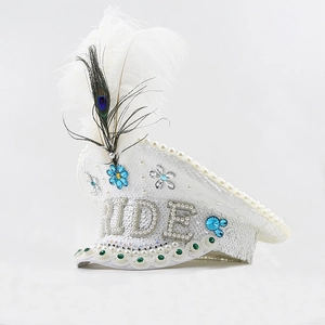 Close-up of white sequin captain hat with BRIDE text, pearls and peacock feathers