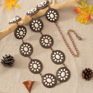 Macro shot of boho concho belt with vintage copper discs and white marble stones