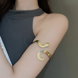 Détail d'un bracelet de bras serpent doré poli avec un design en spirale minimaliste