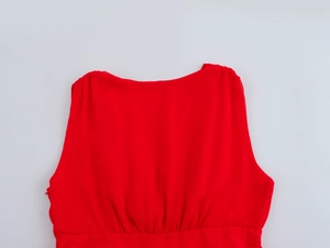 Detail of red sleeveless dress with hidden side zipper and pleated waist on chiffon fabric