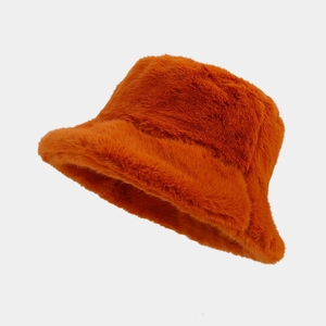 Detail of plush faux rabbit fur texture on a warm caramel orange winter bucket hat