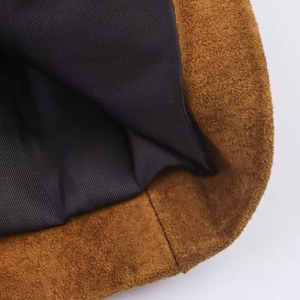 Détail macro d'une veste en daim marron foncé avec doublure noire et coutures précises