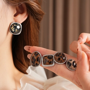 Détail de boucles d'oreilles vintage léopard en résine de formes carrées
