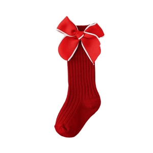 Red knit baby knee high socks featuring a large bow and classic vertical ribbed texture