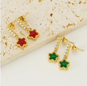 Detailed close-up of gold star earrings with pearls and red green gemstones