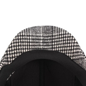 Detail shot of black and white plaid newsboy cap showing tweed texture and elastic sweatband