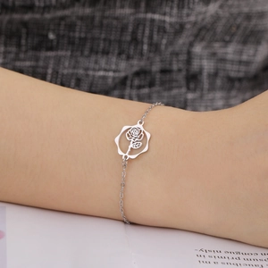 Detailed close-up of a hollow rose pendant bracelet in polished silver finish on a wrist