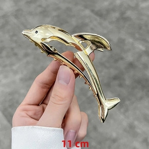 Detail view of 11cm golden dolphin hair claw clip with metallic finish and anti-slip teeth