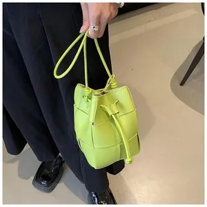 Detailed close-up of neon green woven leather mini bucket bag with drawstring closure